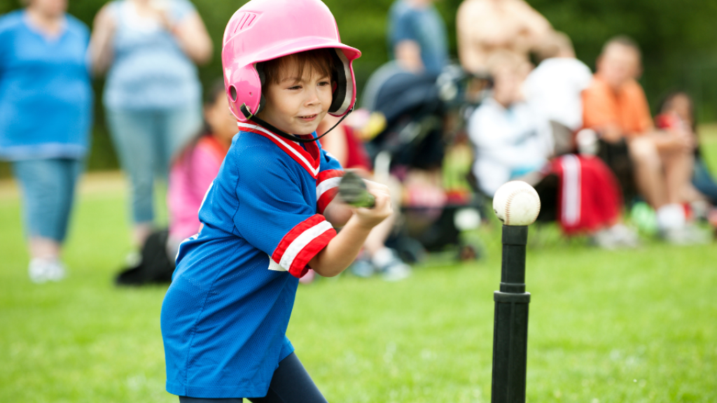 Tee ball player hitting ball off stand.