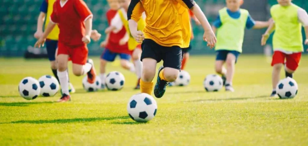 Soccer players dribbling ball.