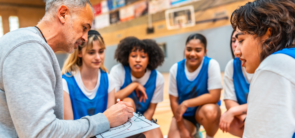 basketball coach and players in huddle.