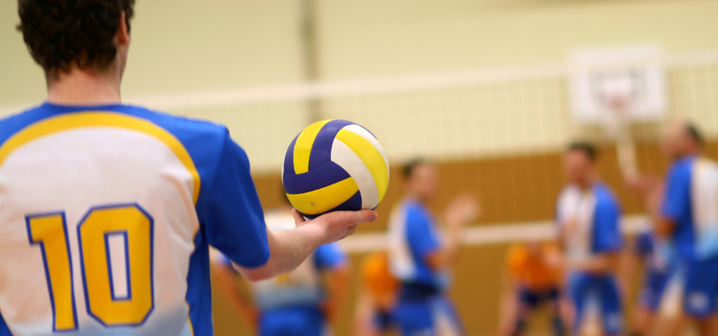 Volleyball player setting up for underhand serve.