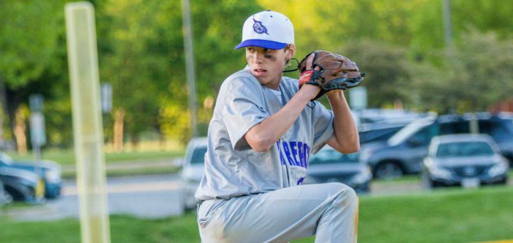 Baseball player winding up throw.
