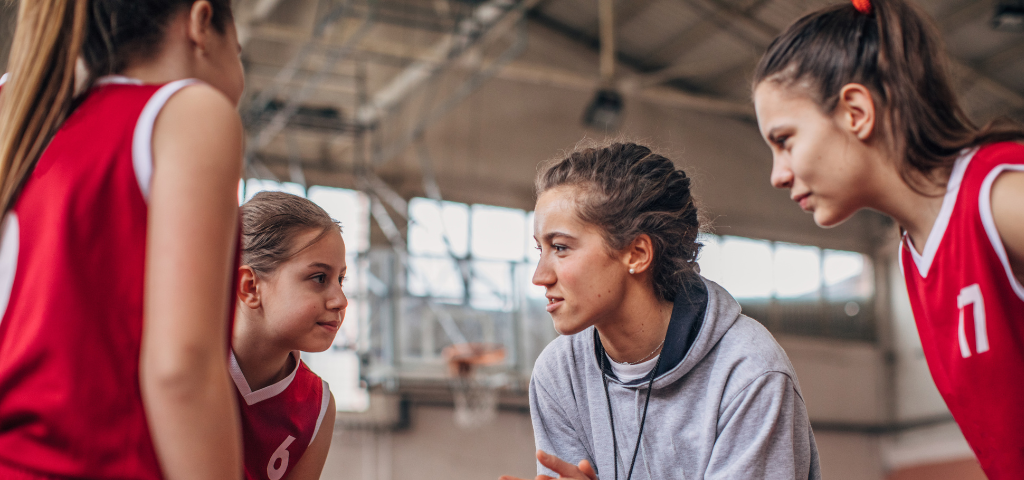 Athlete and coach huddle.