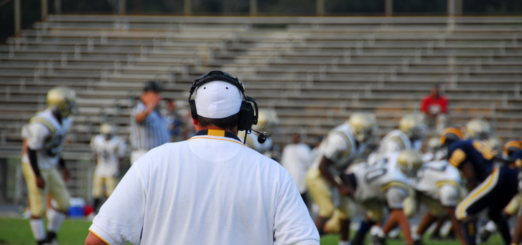 Coach looking out onto football field.