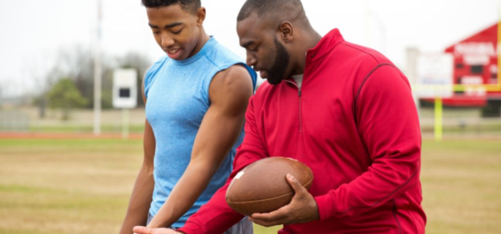 Football coach training football player.