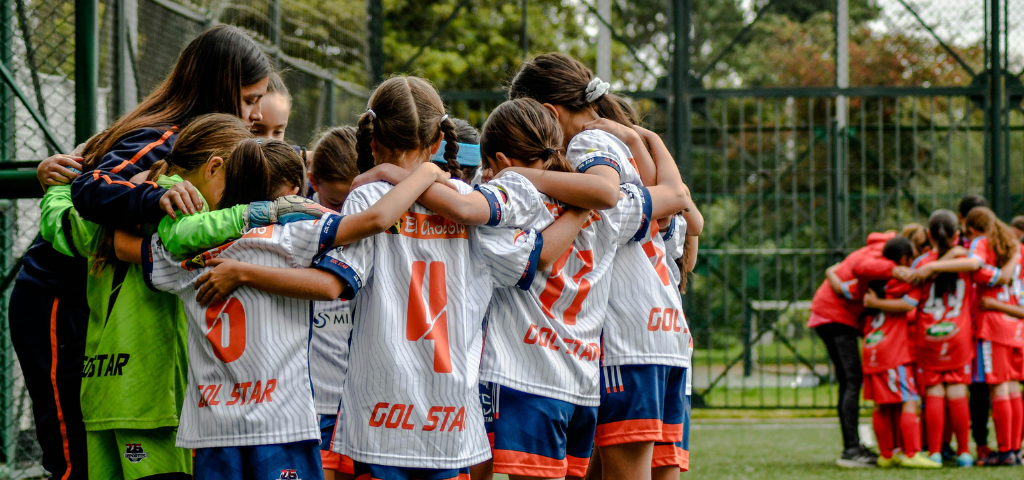 Coach & athletes in a huddle.