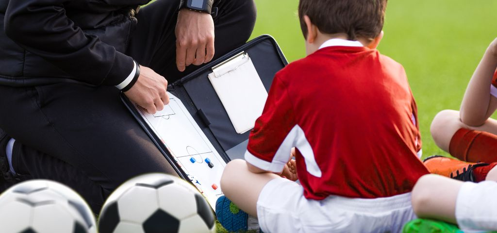Youth soccer coach explaining drills.