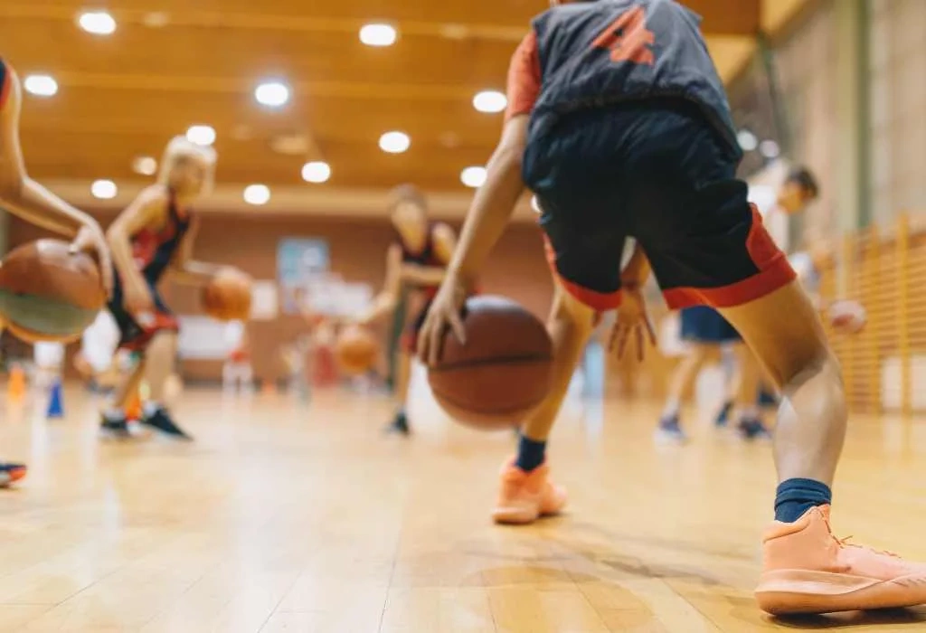 Player dribbling basketball between legs.