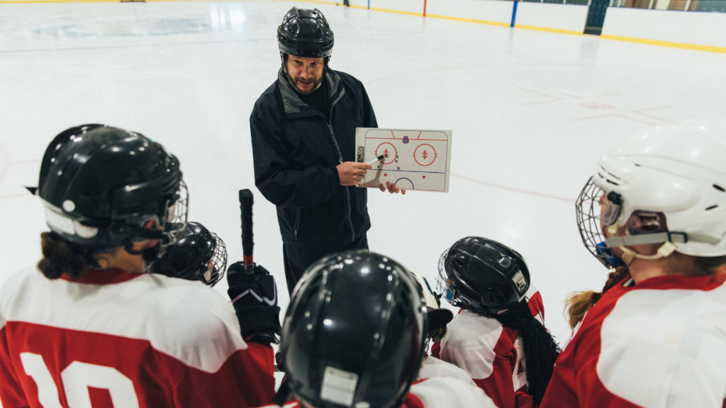 Hockey coach with clipboard showing players.