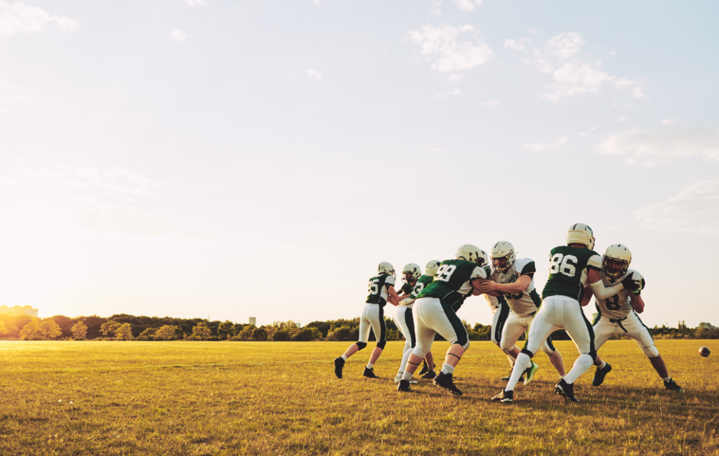 Football players tackling on field.