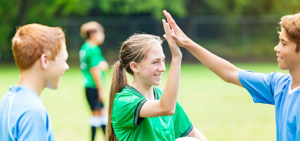 Youth soccer players high fiving.