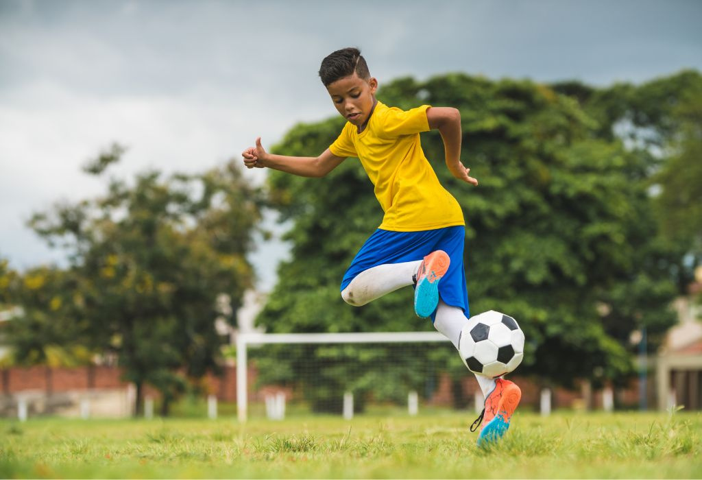 Soccer player kicking ball back.