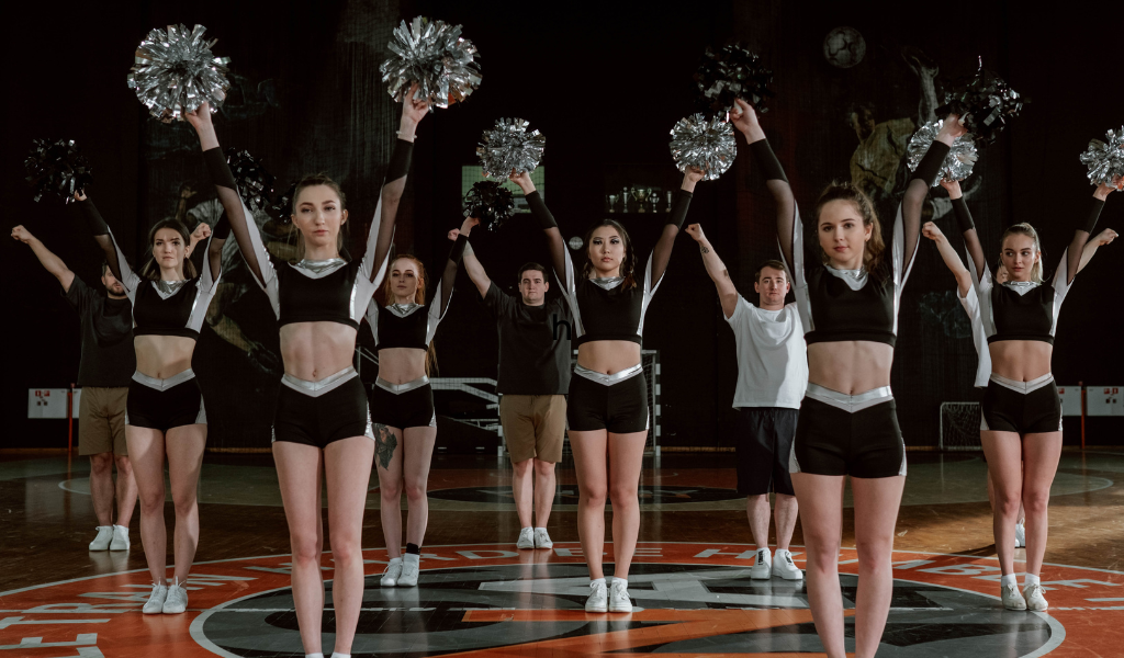 Cheerleaders with hands in high V.