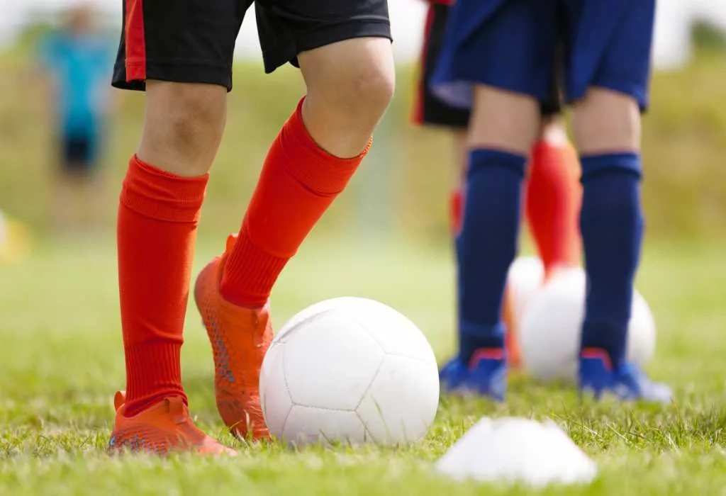 Player with foot under soccer ball.
