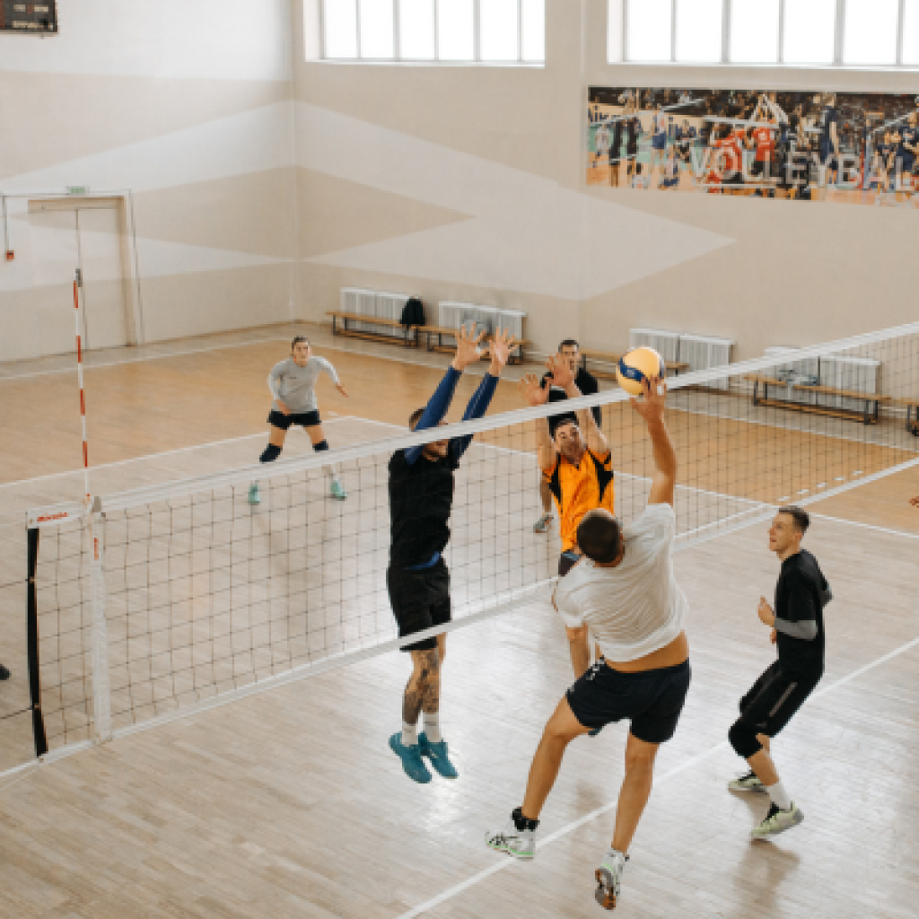 Volleyball player spiking ball over net.