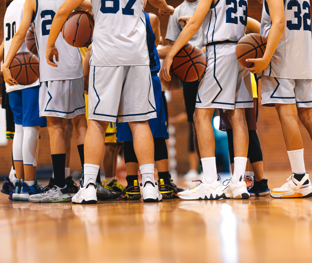 Basketball players on court in huddle.