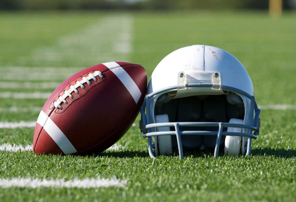 Football and helmet on field.